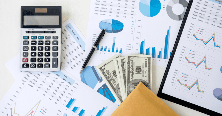 Financial data scattered on a table with a calculator, pen, and dollar bills. Get help from our expert small business accountants in Sydney for tax planning and preparation.