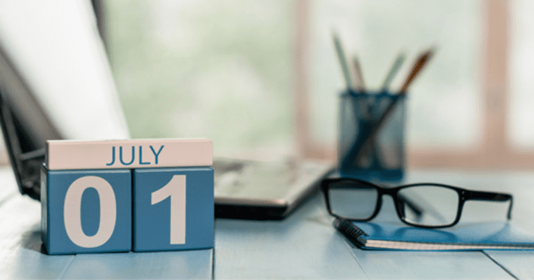 A laptop and a note with a sunglass on top, along with a calendar block displaying the date July 01. Don't forget to prepare for tax season with our small business accountants in Sydney.