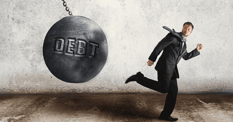 A man running away from a swinging block labeled "debt." Our tax accountants in North Sydney can help you avoid debt and plan for financial success.