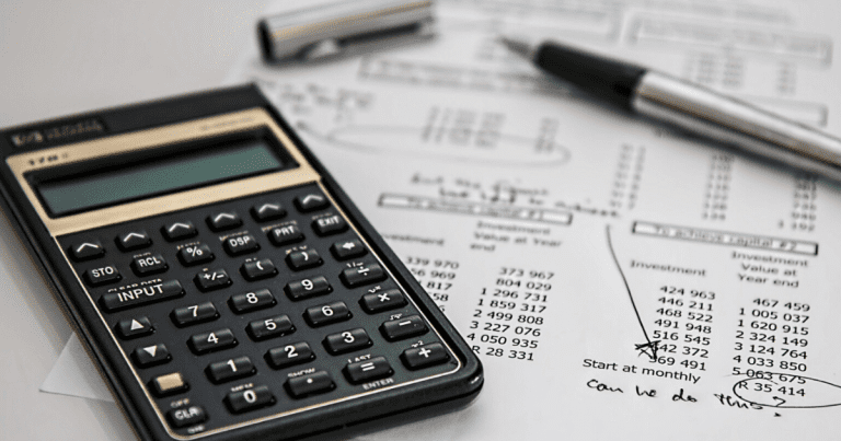 A close-up image of financial computations with a calculator and pen on top. Contact our tax accountants in Sydney for assistance with your financial planning and tax preparation.