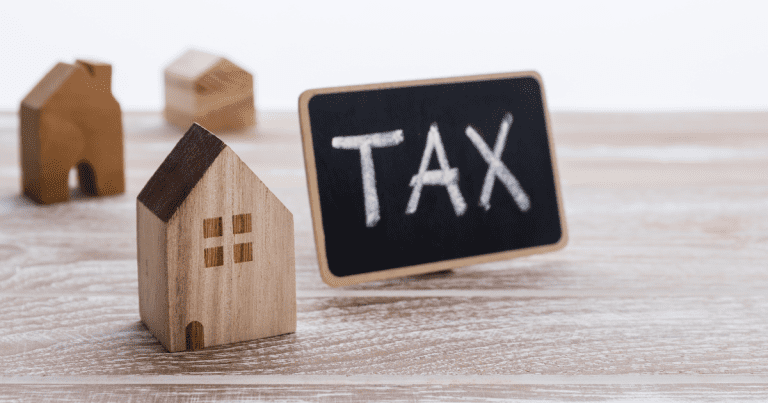 A miniature house with a label "TAX" next to it. Contact our tax accountant near you in Sydney to stay compliant with tax regulations and optimise your financial strategy.