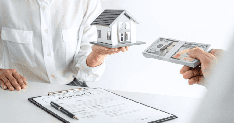 Small business accountant overseeing a real estate transaction with a miniature house and tied dollar bills exchanged over a contract on a table.