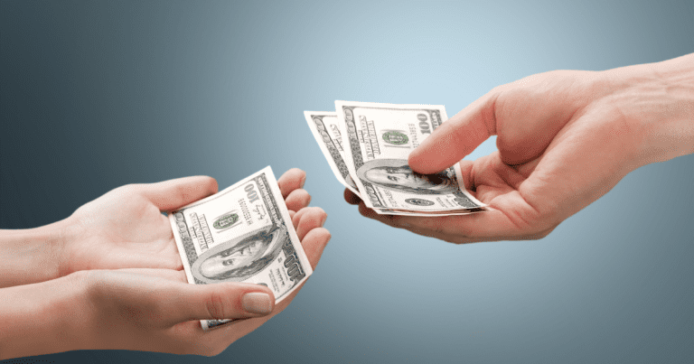 A pair of hands exchanging money, one hand holding a single dollar bill while the other hand holds two dollar bills, symbolising the services of a small business accountant.