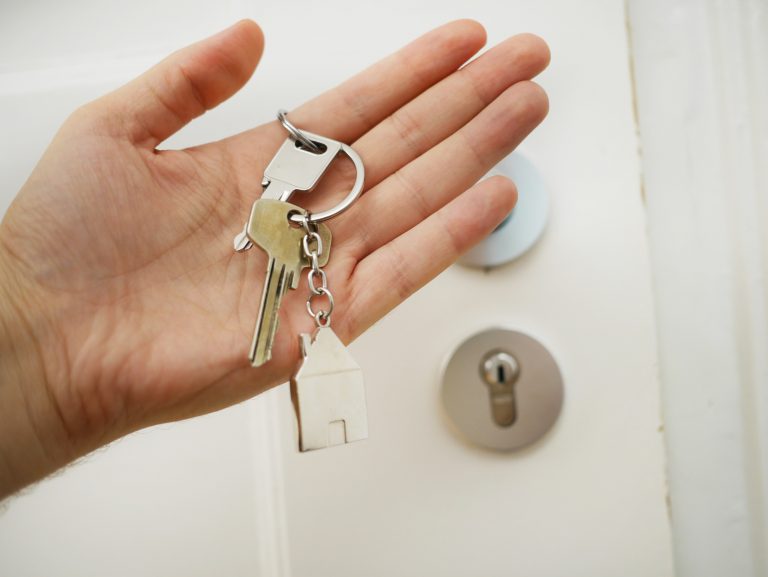 A hand holding a keychain with keys and a small house figurine symbolise the significance of safeguarding the family home through an ideal accounting firm in Sydney.