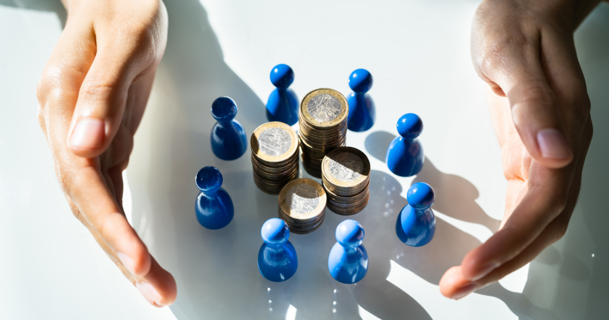 A pair of hands holding stacks of coins and miniature figures. Trust our small business accountants in Sydney to help you maximize your profits and manage your finances effectively.