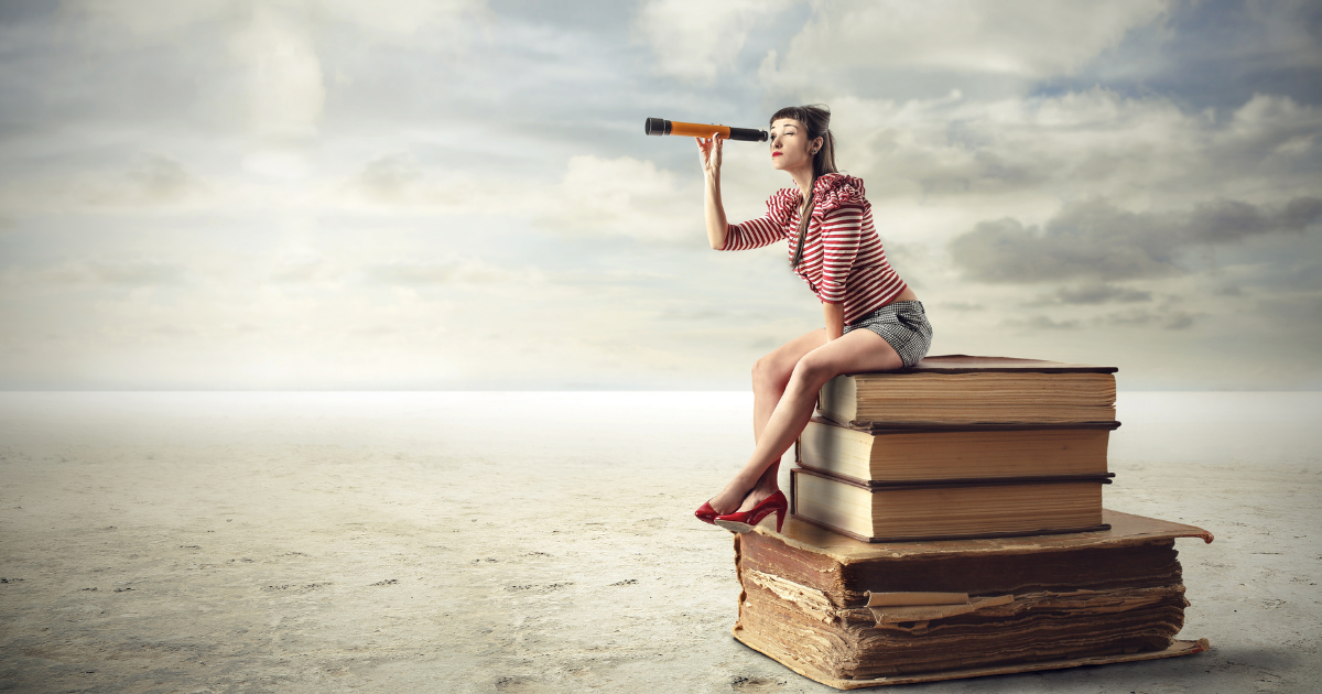A woman using binoculars while sitting on top of stacked books. Contact our accounting firm in Sydney for expert financial advice and bookkeeping services.