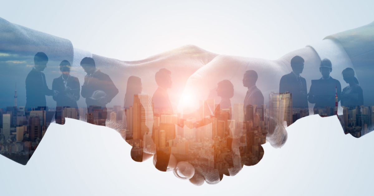 Two individuals are shaking hands in front of a backdrop featuring a silhouette of business entrepreneurs and industrial buildings, highlighting the importance of small business accountants in helping entrepreneurs navigate the complex financial landscape of running a business and achieving success.