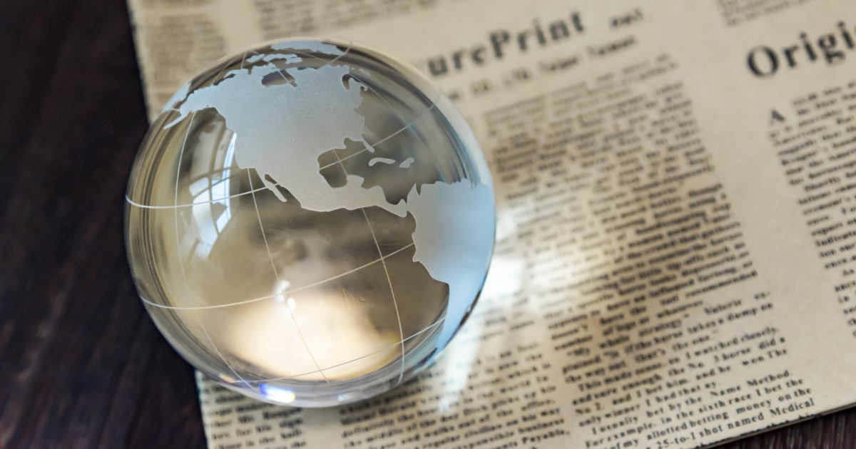A newspaper with tax-related headlines and a small globe placed on top. Our small business accountants in Sydney can help you navigate complex tax laws and regulations.