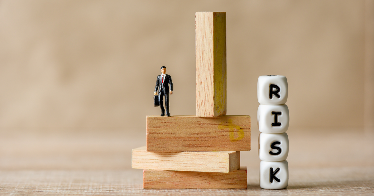 A business accountant in Chatswood stands on a pile of wooden blocks, representing the importance of taking calculated risks in financial planning and decision-making.