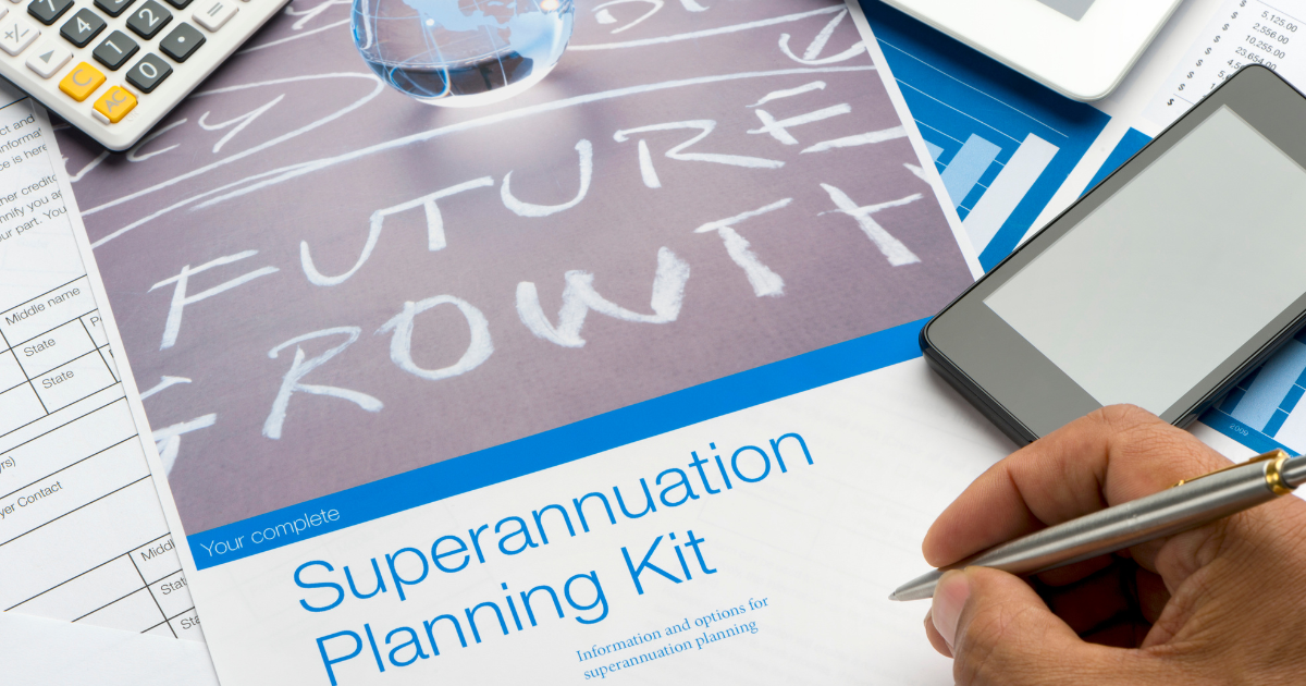 A hand holding a pen over a superannuation planning kit, typically handed over by your chosen accounting firm in Sydney, with a phone, calculator, and globe nearby.