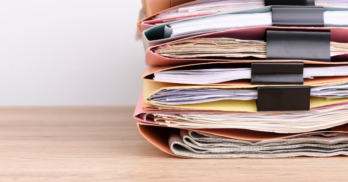 A stack of business records, such as financial statements, receipts, and invoices, piled up and organised neatly, representing the importance of proper record-keeping and bookkeeping for businesses. Contact our accounting firm in Sydney for help with organising and managing your business records.