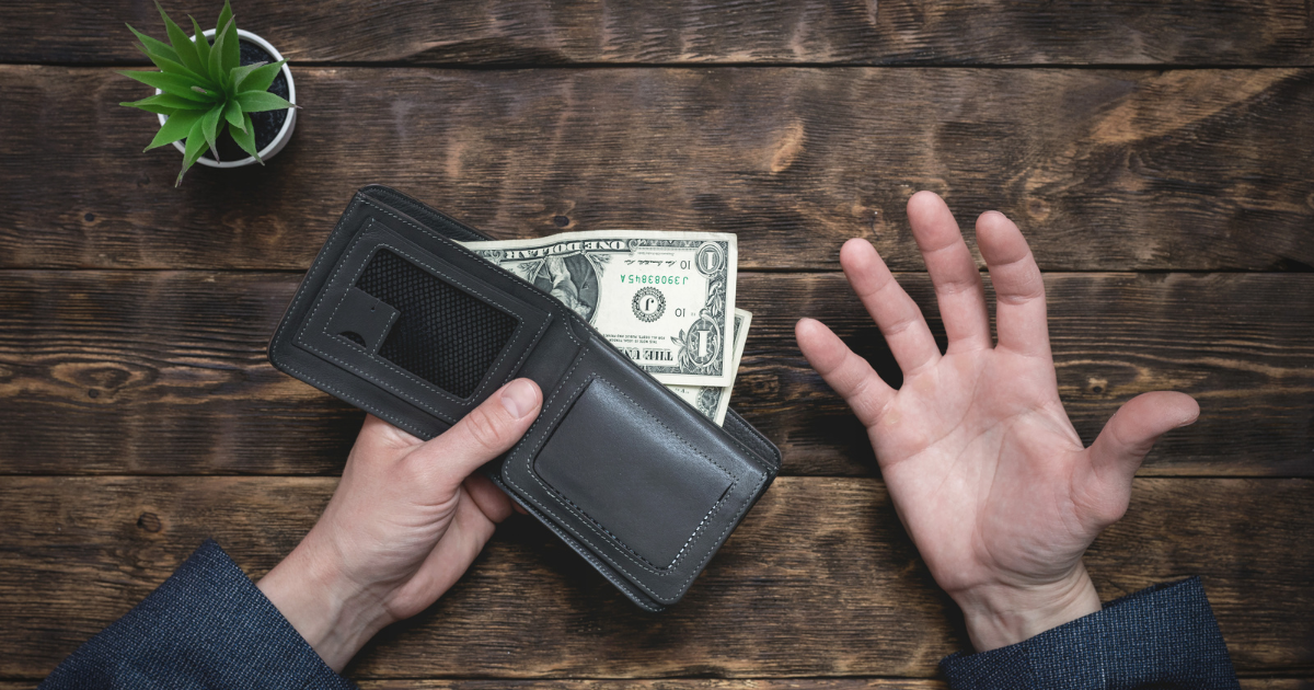 A hand holding an open wallet with two bills partially visible and showing signs of frustration. Contact our tax accountant near you for financial planning and budgeting assistance.