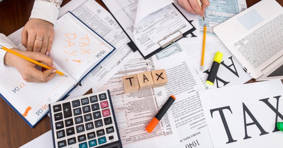 Tax-related documents, pens, and markers scattered on a table. Let our expert tax accountants in Sydney help you navigate tax laws and maximise your tax savings.