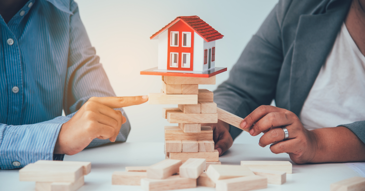 Two people playing with wooden blocks, with a miniature house on top. Contact our small business accountants for help with managing your finances and building a solid financial foundation for your future.